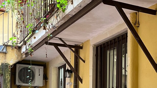A building entrance with a tiled floor, a large potted plant, and a window with bars. - GeLiRò Apartment Catania Centro - Comfort, style and perfect location (Catania)