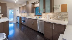 A modern kitchen with dark wood cabinets, stainless steel appliances, and a tiled backsplash.