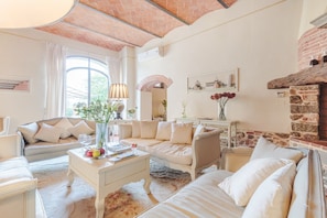 A spacious living room with a sofa, coffee table, and a fireplace.