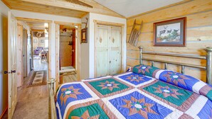 A wooden cabin bedroom with a bed, a ceiling fan, and a framed picture on the wall. - Roberts Home w/ Western Decor & Mountain Views! (Roberts)