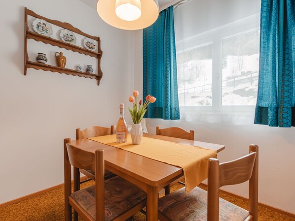 Enjoy a romantic dinner for two in this beautifully set dining area with a vase of fresh flowers and a bottle of wine.