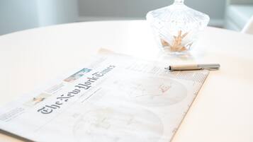A clear view of a newspaper with the title "The New York Times" on a white table.