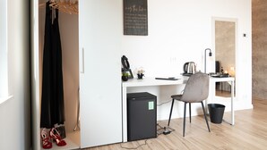 A compact room with a desk, chair, and a small refrigerator. - Villa Tosati (Monza)