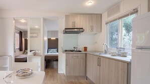 A modern kitchen with wooden cabinets, a gas stove, and a window providing natural light.