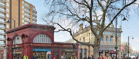 A street scene with a red building labeled "GLOUCESTER ROAD STATION" and a tree in the foreground.