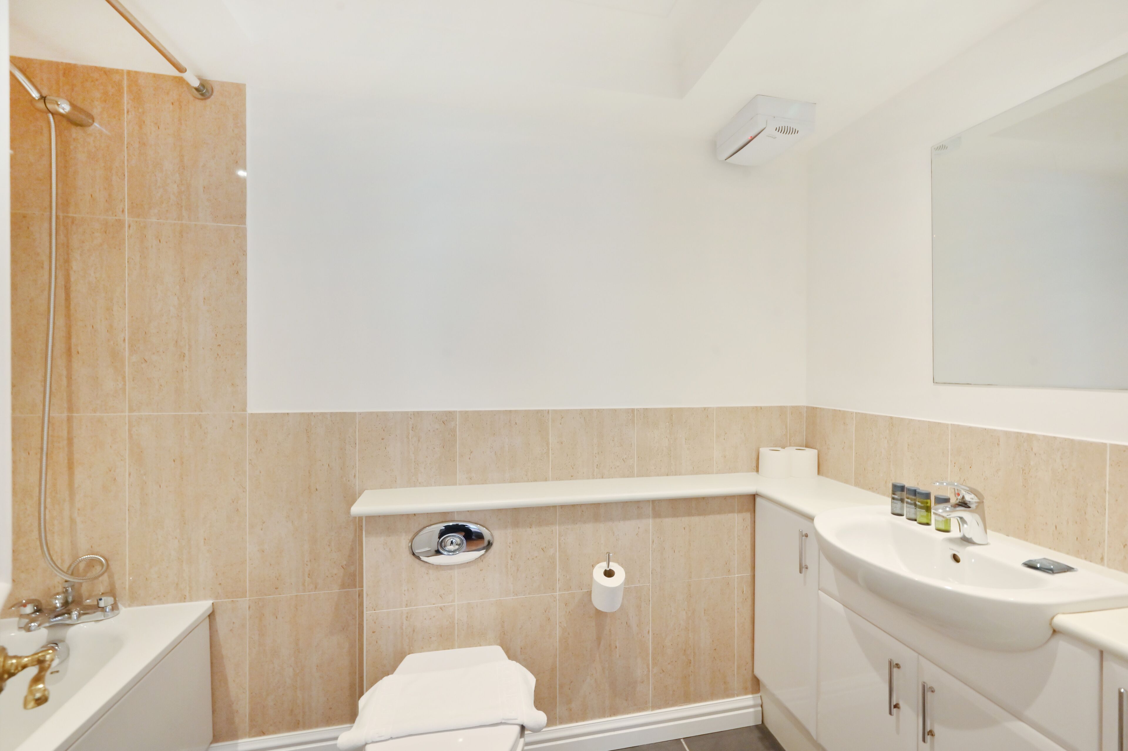A modern bathroom with a bathtub, toilet, sink, and a mirror.