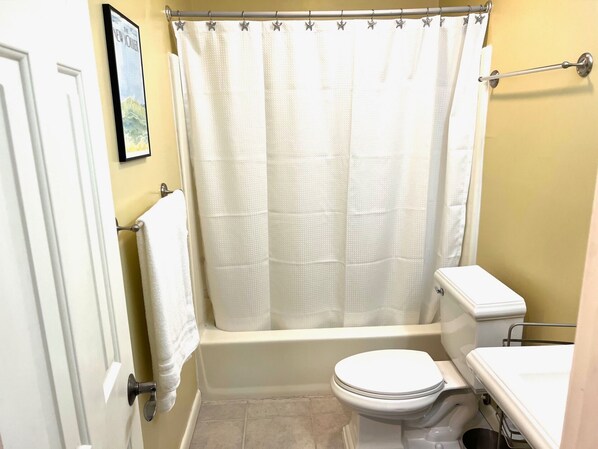 Une salle de bain équipée d’une baignoire, de toilettes et d’un rideau de douche décoré d’étoiles.