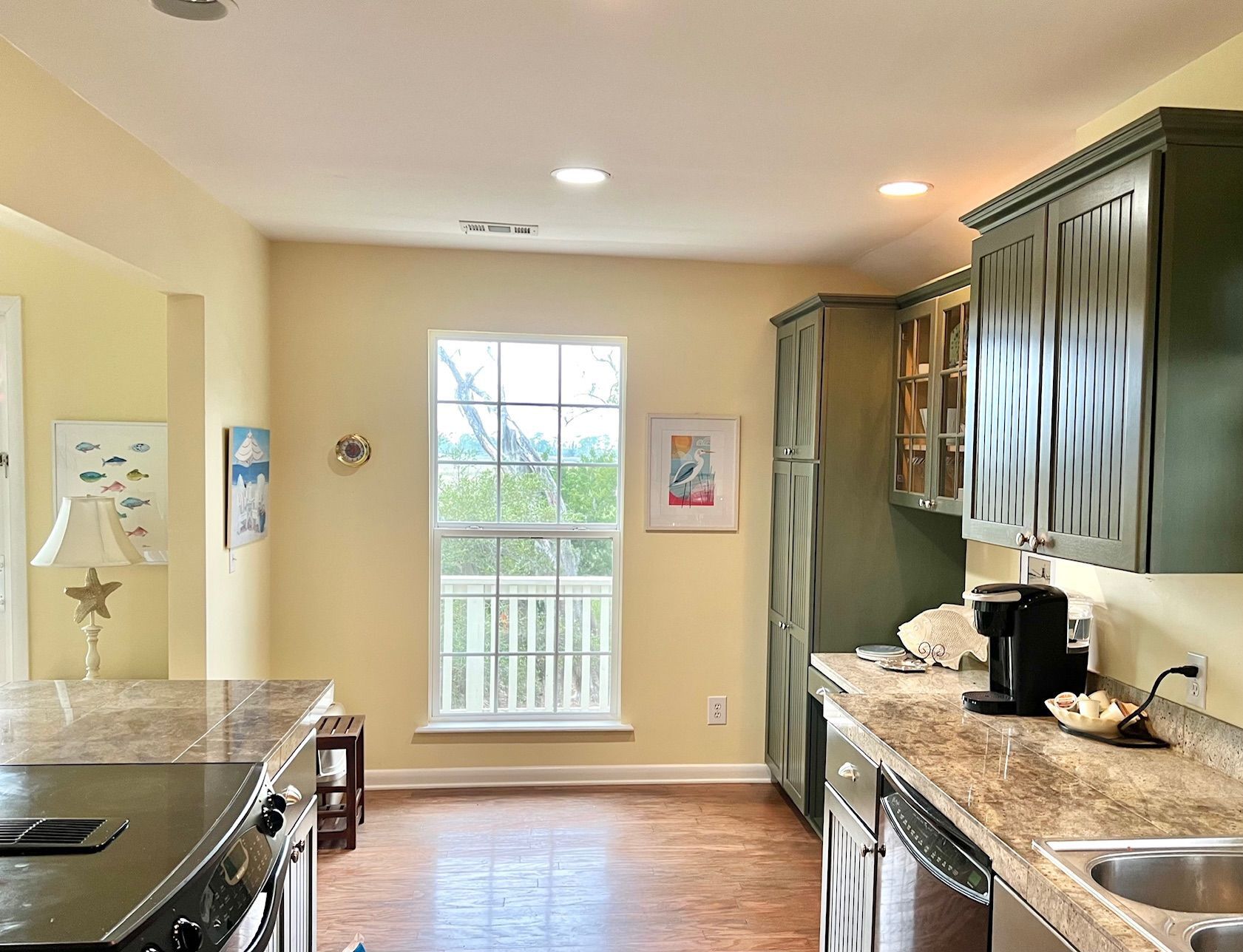 A kitchen with a large window, wooden cabinets, and a built-in oven.