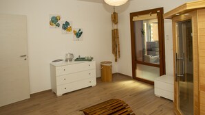 A modern bathroom with a wooden bench, a white cabinet, and a glass shower enclosure. - Modern Villa with heated jacuzzi,sauna,panoramic view,close to Tuscany (Pergoloso)