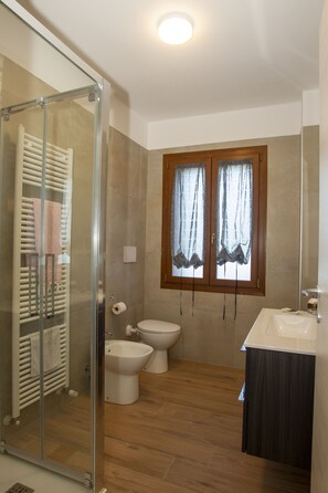 A bathroom with a glass shower enclosure, a toilet, a bidet, and a sink. - Modern Villa with heated jacuzzi,sauna,panoramic view,close to Tuscany (Pergoloso)
