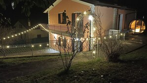 A two-story building with a balcony and string lights. - Modern Villa with heated jacuzzi,sauna,panoramic view,close to Tuscany (Pergoloso)