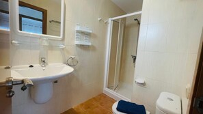 Enjoy a refreshing shower in this bathroom featuring a pedestal sink, glass shower enclosure, and handheld showerhead.