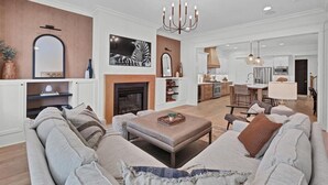 Una sala de estar moderna con chimenea, un comedor y una cocina.