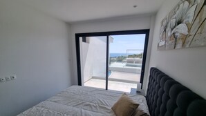 A bedroom with a bed, a window, and a view of the sea. - Cap malouins  - Four Bedroom Villa, Sleeps 8 (Roquebrune-sur-Argens)