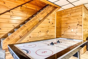 Enjoy a game of shuffleboard or air hockey at this cozy space with a central table and control panel.