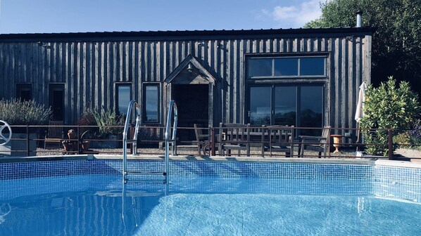 Enjoy a refreshing dip in the pool surrounded by outdoor seating areas with tables and chairs.