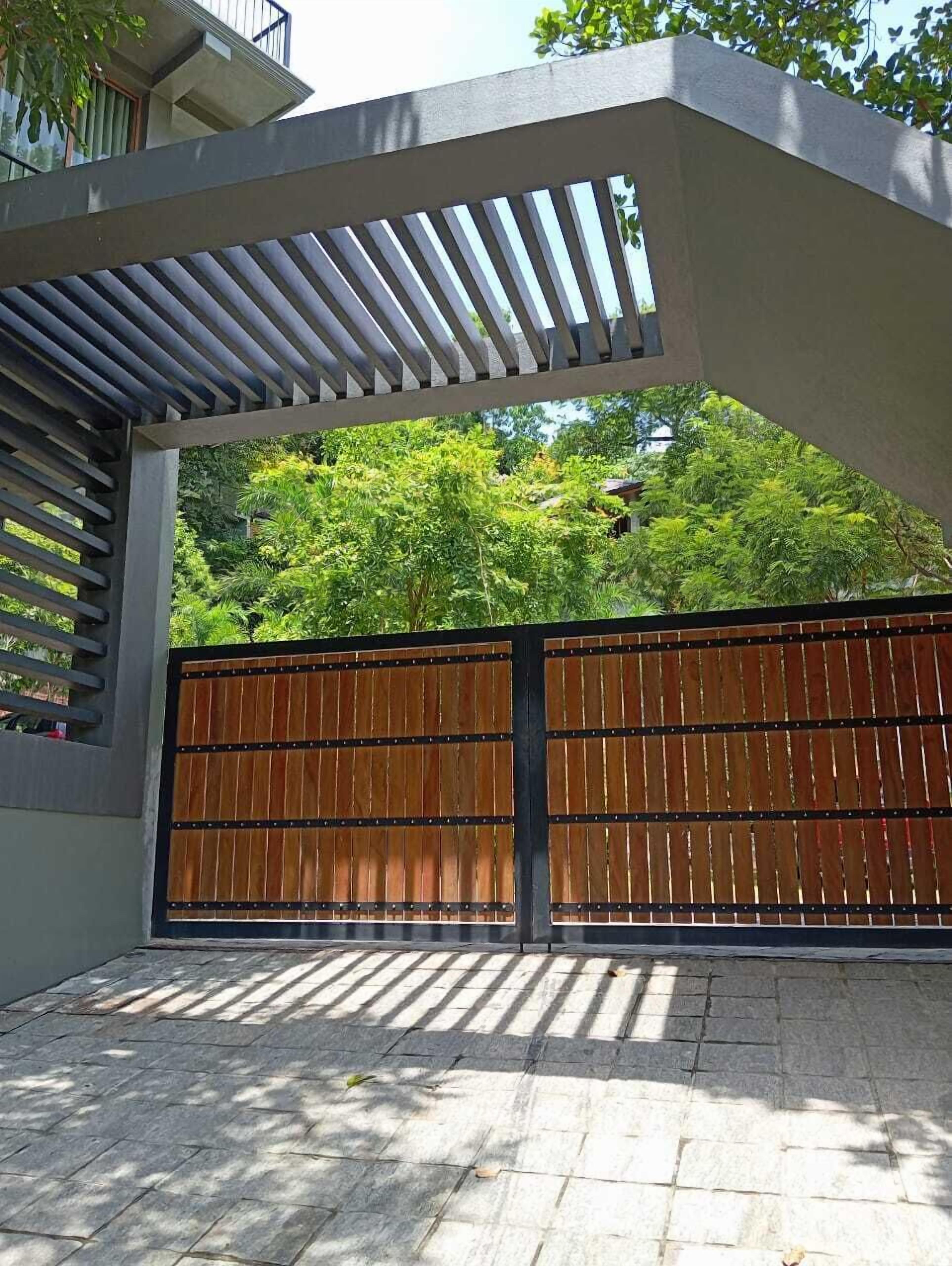 A modern outdoor area with a concrete structure, a wooden fence, and a stone-paved ground.