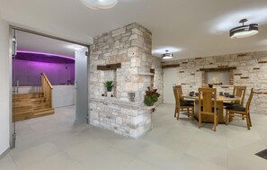 Experience a clean, minimalist space with a dining area and staircase leading to a separate area.