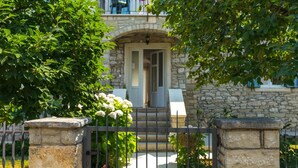 A stone building with a stone entrance, a metal gate, and a pathway leading to the entrance. - Cozy apartment in Umag with private swimming pool, can be inside or outside (Umag)