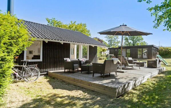A wooden deck with outdoor furniture and a bicycle. - Beautiful home in Odder with WiFi (Odder)
