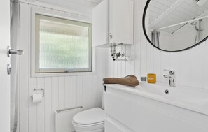 A bathroom with a toilet, a sink with a mirror, a window, and a shower. - Beautiful home in Odder with WiFi (Odder)