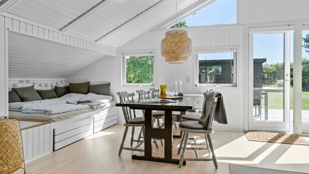 A bright, white interior with a loft bed, a dining table with chairs, and large windows offering a view of the outdoors. - Beautiful home in Odder with WiFi (Odder)