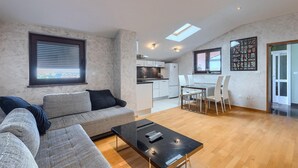 Una sala de estar moderna con un sofá, una mesa de centro y un comedor con sillas y una mesa.