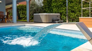 A swimming pool with clear water, a hot tub, and a covered patio area. - Awesome home in Porec with sauna (Porec)