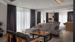A modern living room with a sectional sofa, a wooden coffee table, and a dining area with a table set for six.
