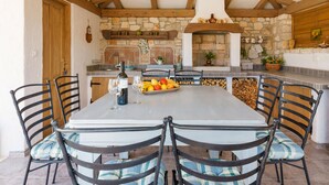 A rustic kitchen with a stone wall, wooden beams, and a built-in oven. - Beautiful home in Porec (Porec)