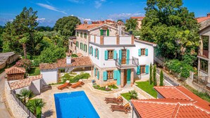 A multi-story villa with a swimming pool, outdoor seating, and lush greenery. - Beautiful home in Porec (Porec)