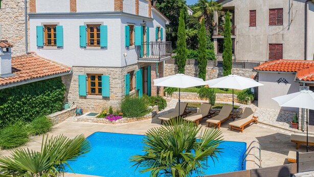 A poolside area with a swimming pool, lounge chairs, and umbrellas. - Beautiful home in Porec (Porec)