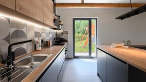 A modern kitchen with a large window, stainless steel appliances, and a wooden ceiling. - Amazing home in Vizinada (Vizinada)