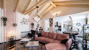 Un saló modern amb un sofà modular, una taula de centre de vidre i una zona de menjador amb un candelabrum.