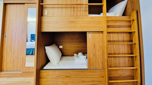 A bunk bed room with wooden walls and a ladder. - Chasse Residency Hotel (Amsterdam)