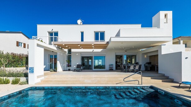 A modern two-story house with a swimming pool, outdoor seating, and a covered patio area. - Stunning home in Porec (Porec)