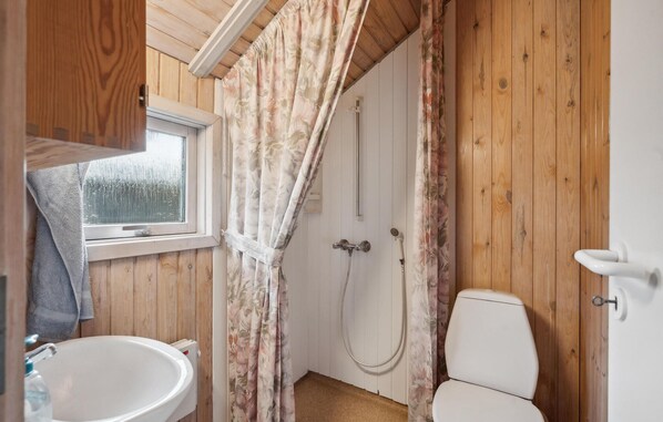 A bathroom with wooden walls, a white sink, a toilet, and a shower area. - Nice home in Hovborg with WiFi (Hovborg)
