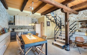 Cozy kitchen with a modern layout, microwave, sink, and ample counter space, featuring a dining table and chairs.