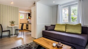 Un salon avec un canapé, une table basse et une vue sur la cuisine.