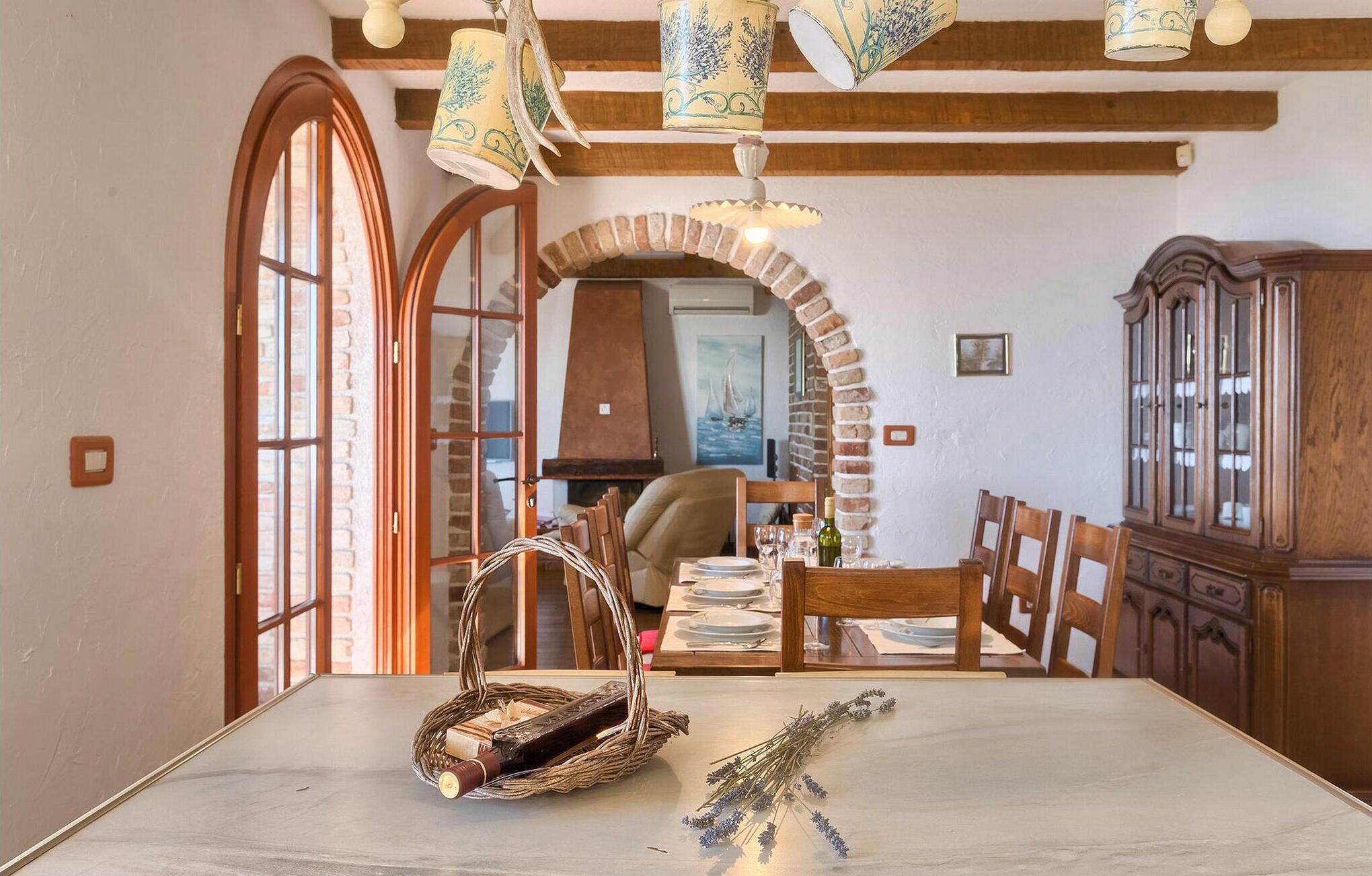 Un coin repas avec une table en marbre, un panier en osier et de la lavande.