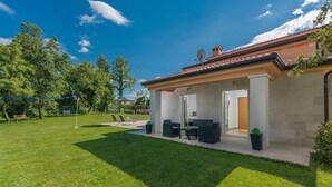 Ett hus med en inglasad uteplats, en gräsmatta och en satellantenn.
