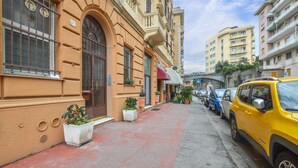 Eine schmale Straße mit parkenden Autos und einem gelben Taxi.