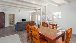 A spacious living area with a dining table, chairs, a sofa, and a staircase. - Amazing home in Tinjan (Tinjan)