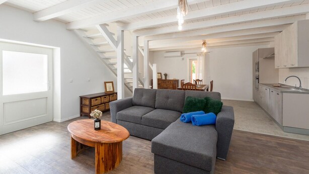 A spacious living room with a gray sectional sofa, a wooden coffee table, and a staircase leading to another level. - Amazing home in Tinjan (Tinjan)