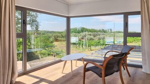 A room with large windows, a wooden floor, a white table, and a wicker chair. - Awesome home in Novigrad (Novigrad)