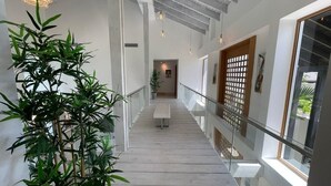 Un interior moderno con una escalera, una planta en maceta y un banco.