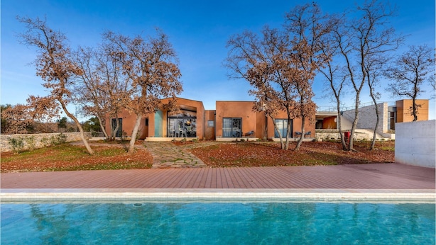 A modern house with a swimming pool, outdoor seating, and a stone wall. - Amazing home in Vodnjan with private swimming pool, can be inside or outside (Vodnjan)