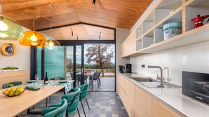 A modern kitchen with a dining area, featuring a wooden ceiling, a large window, and a view of the outdoors. - Amazing home in Vodnjan with private swimming pool, can be inside or outside (Vodnjan)