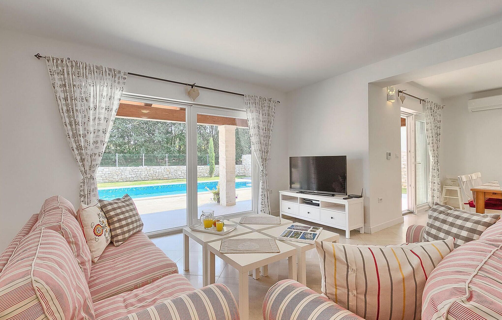 A living room with a TV, sofa, and dining table.