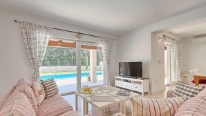 A living room with a TV, sofa, and dining table. - Amazing home in Labin - Rabac (Labin - Rabac)